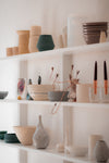 white shelves filled with a variety of pottery