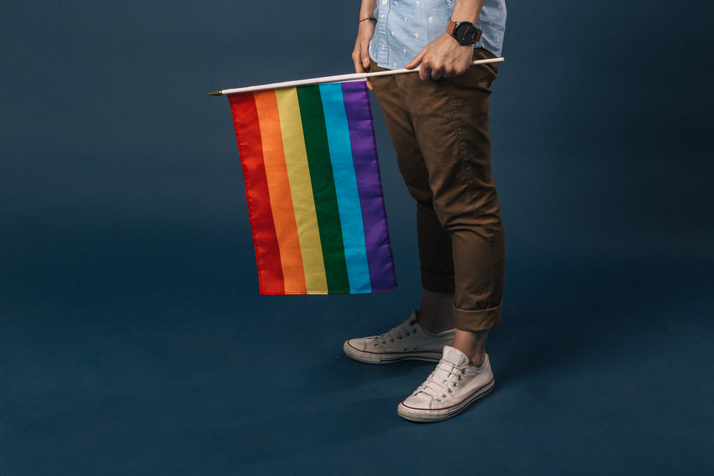 white shoes holding small pride flag