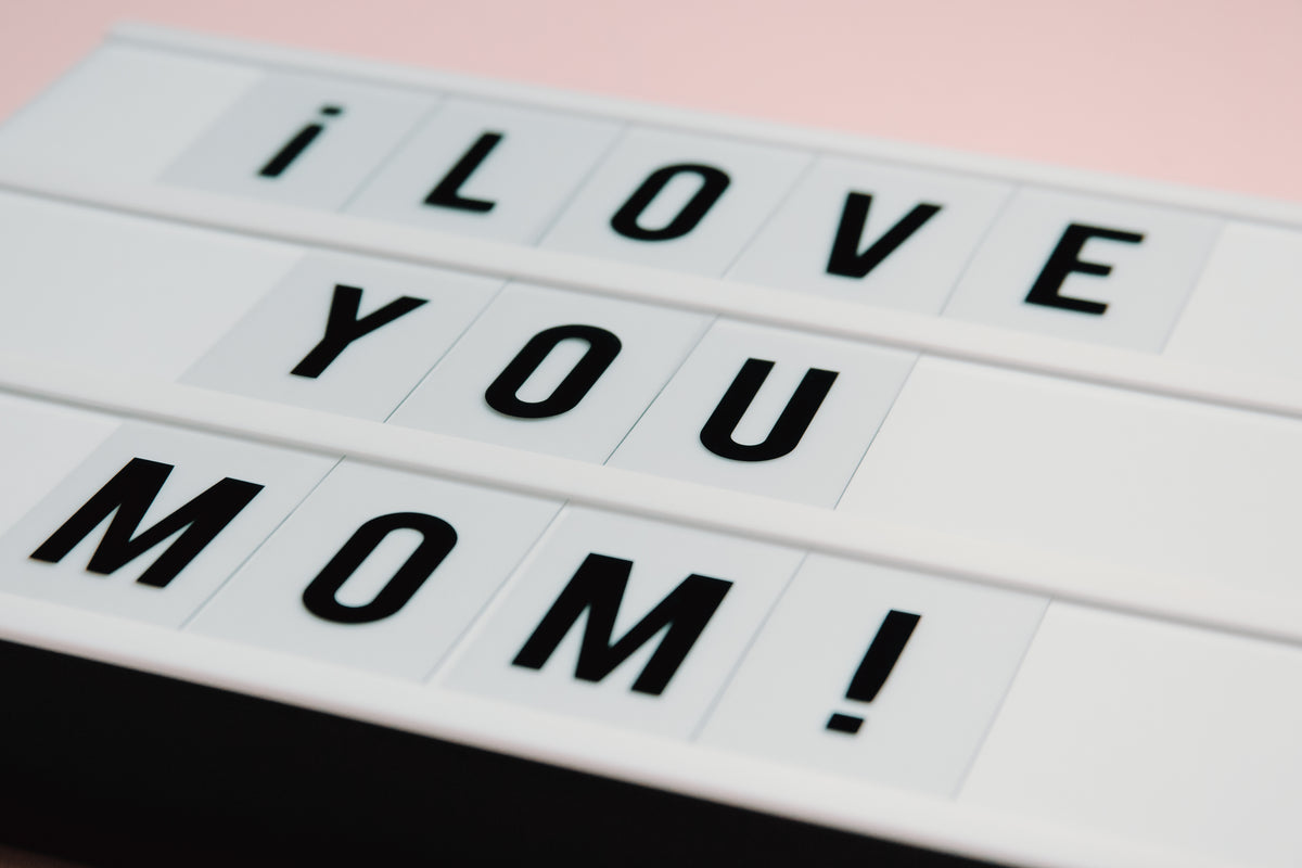 white sign with black text saying i love you mom
