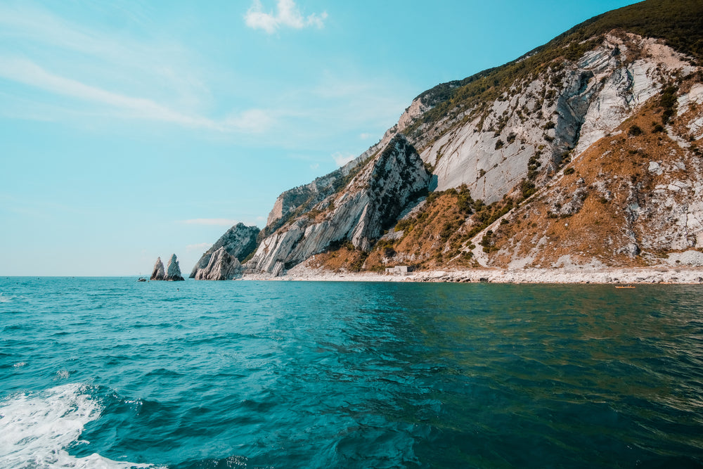 white stone cliffs surrounded by blue water