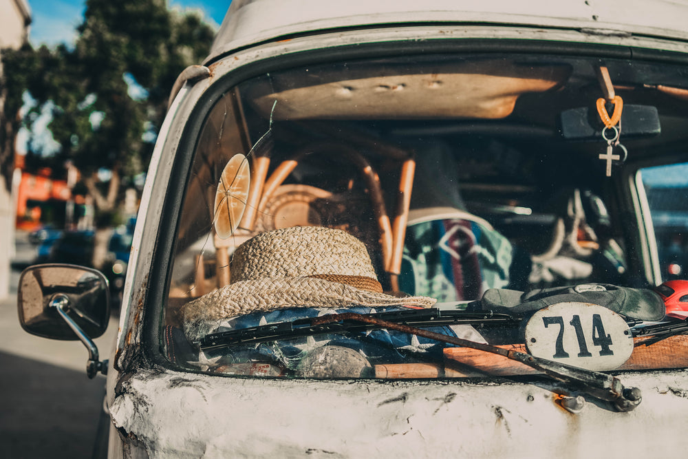 white straw hat sits on a van dashboard