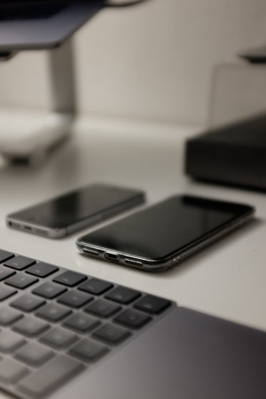 white table with a keyboard and two cell phones