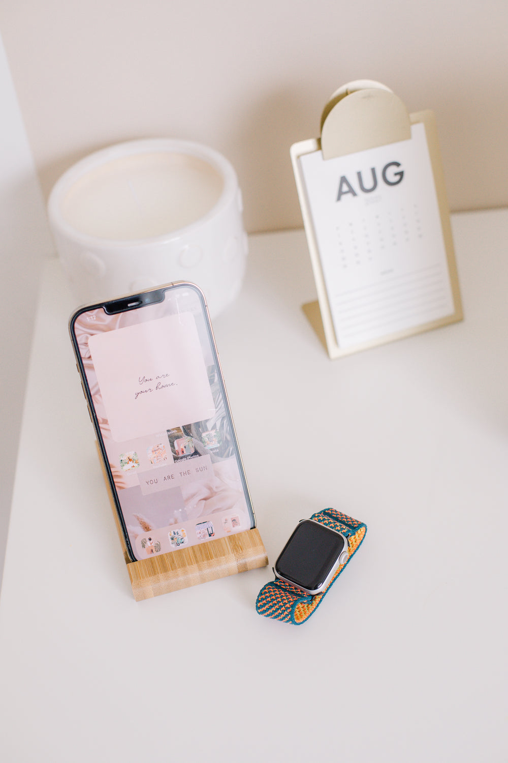 white table with a phone calendar and a white pot