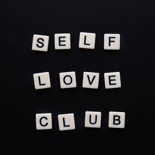 white tiles spell out self love club