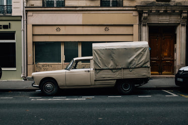 white truck parked outside a large beige building