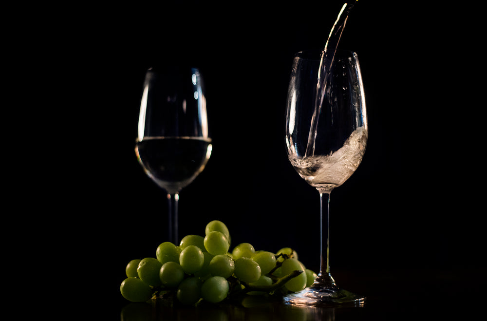 white wine pouring with grapes