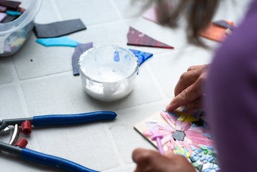 white work bench with a person adding to a mosaic