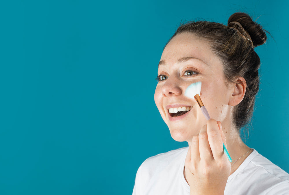 woman adding highlights with a makeup brush