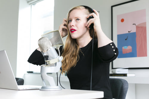 woman adjusting headphones at mic