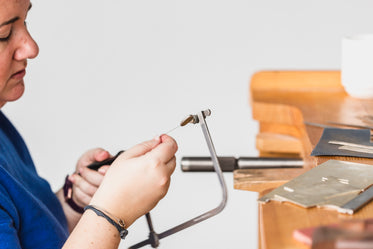 woman adjusts jeweler saw blade