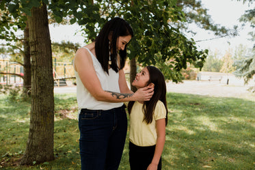 woman and child smile at each other standing outside