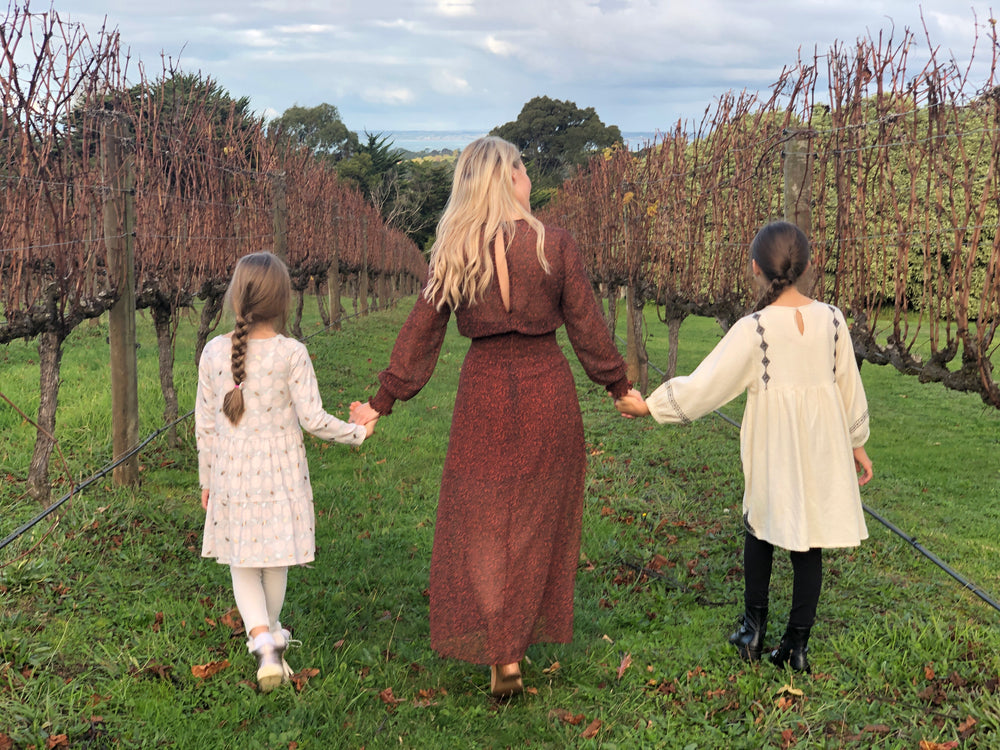 woman and children walk grassy path