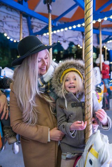 woman and girl on carousel horse