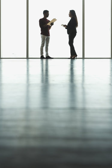 woman and man in front of large windows