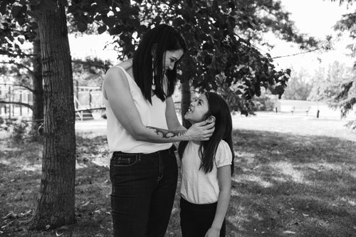 woman and their child stand outside smiling at each other