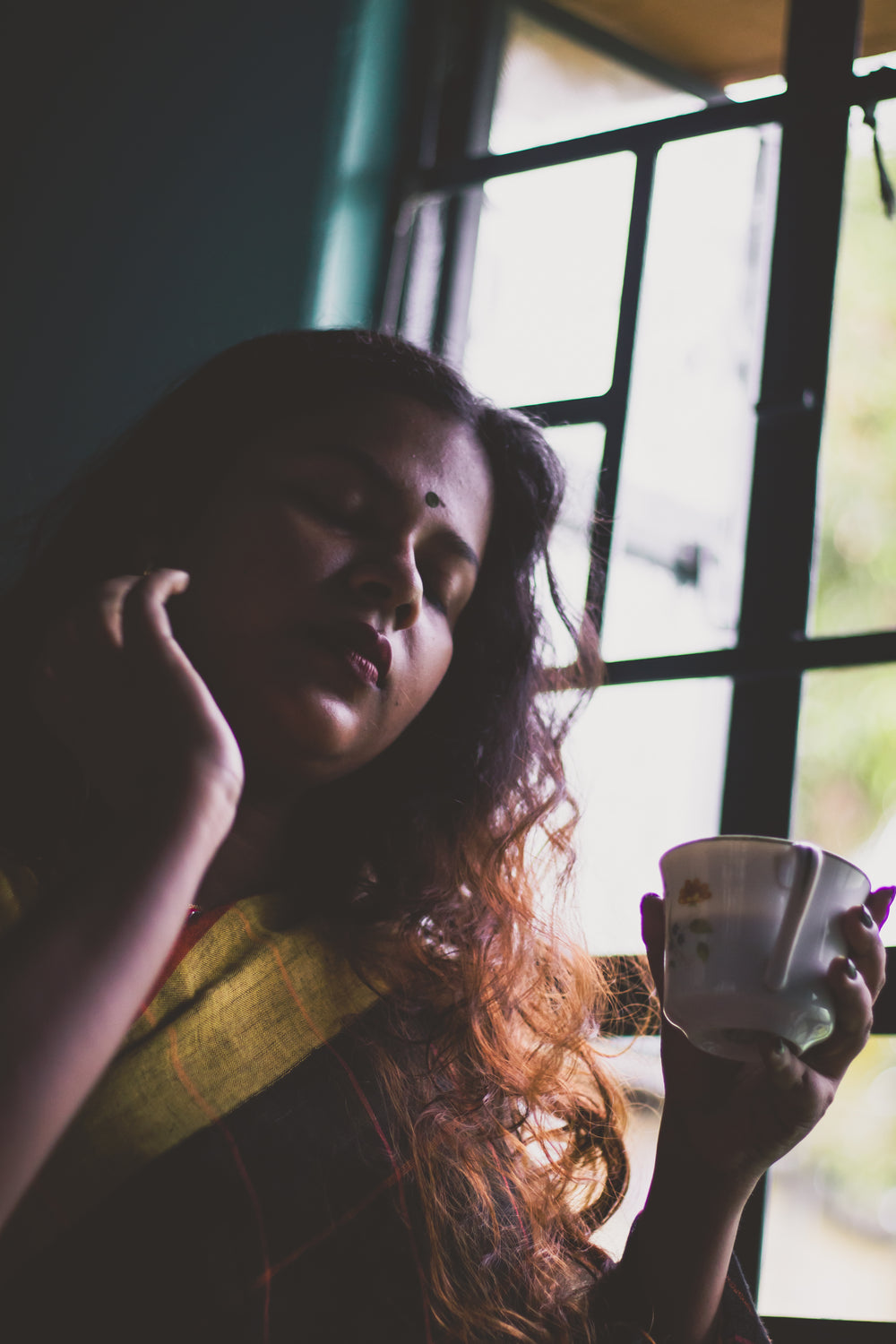 woman at a window drinking her tea