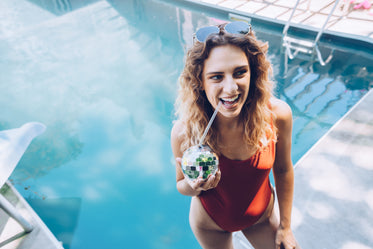 woman by pool with drink