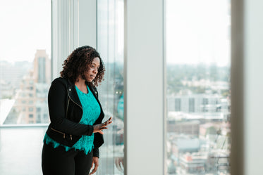 woman by windows looking out to the skyline