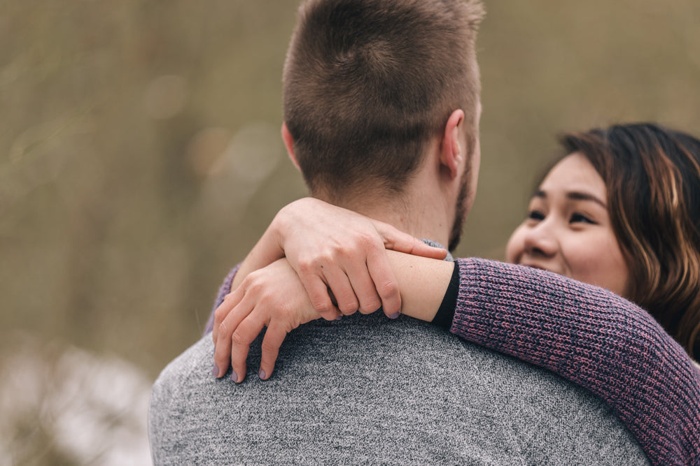 woman clasps two hands behind her partner's neck