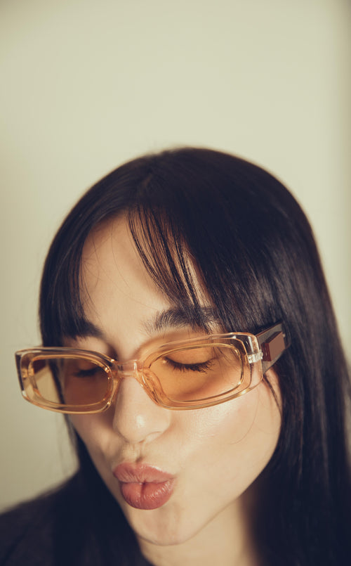 woman close up on orange tinted sunglasses