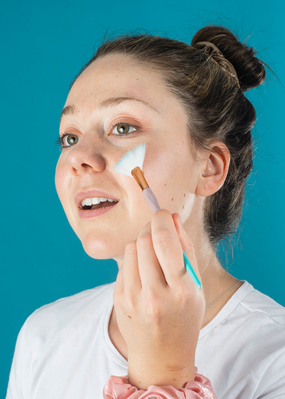 woman concentrates as she does her makeup