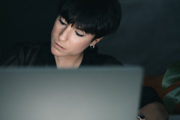 woman concentrates while sitting behind a laptop