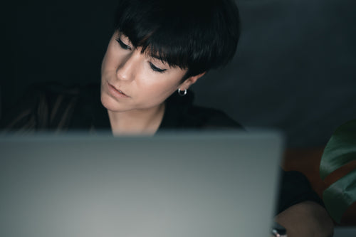woman concentrates while sitting behind a laptop