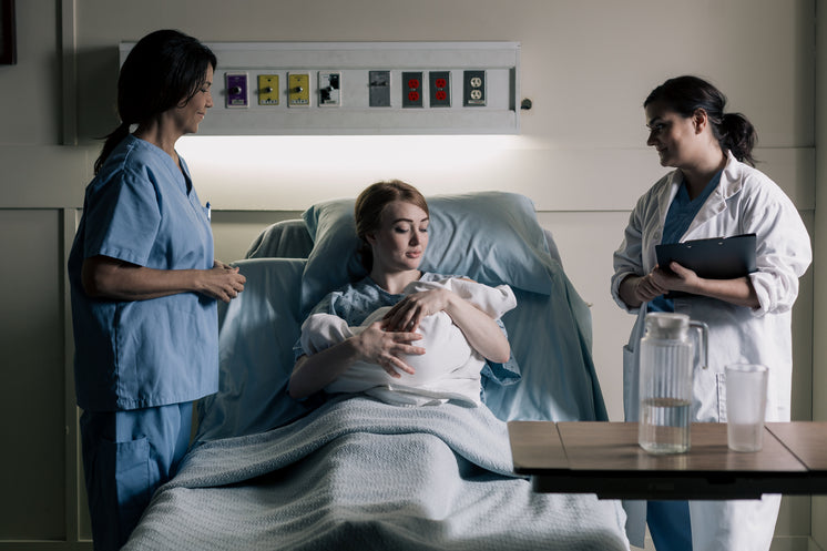 Woman Cradles Newborn Baby Under Watchful Eyes Of Doctors