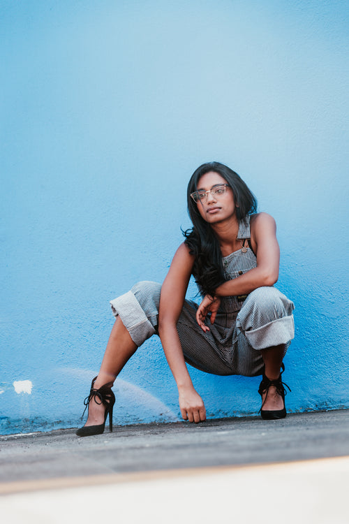 woman crouching by blue wall portrait