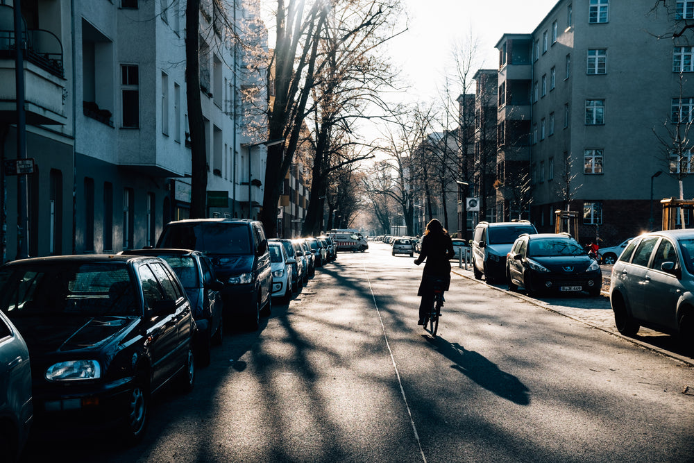 woman cycles down sunny street