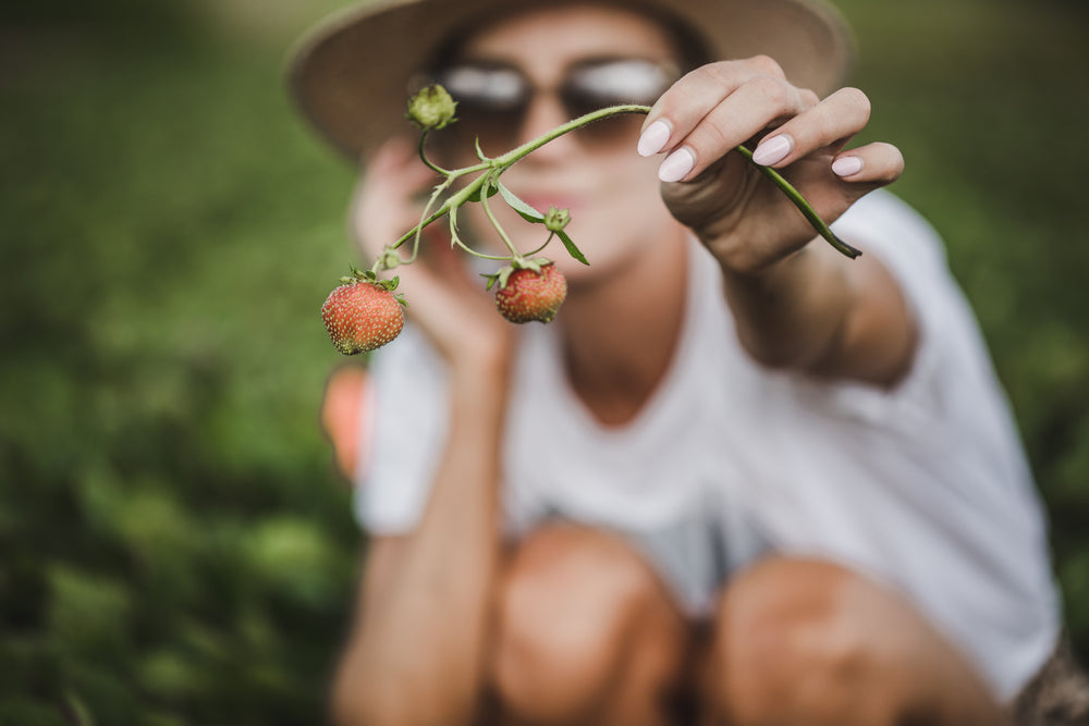 woman displays strawberries