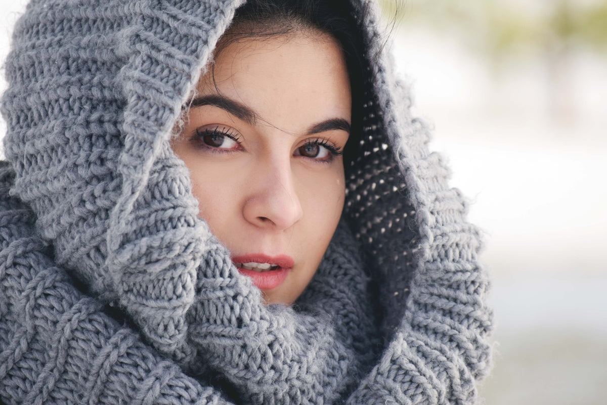 woman draped in knit scarf