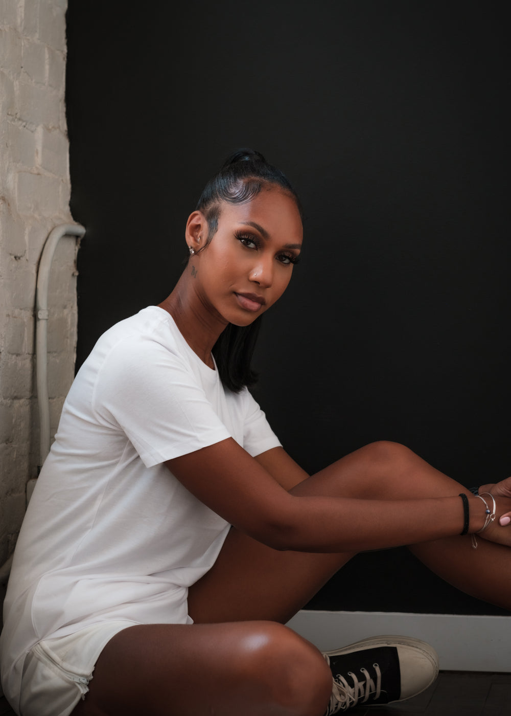 woman dressed in all white sits on the ground