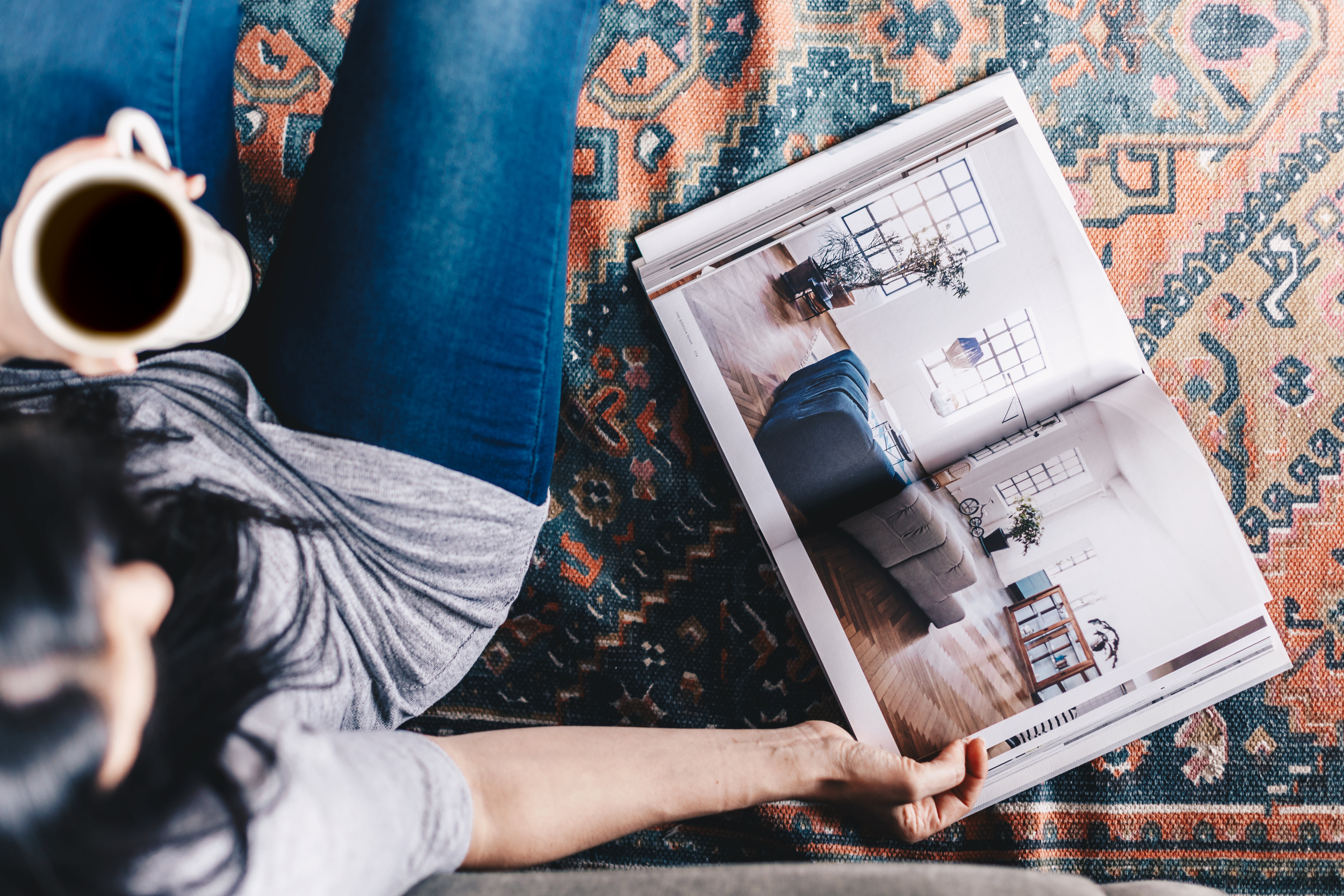 Woman Drinking Coffee And Reading An Interior Design Magazine