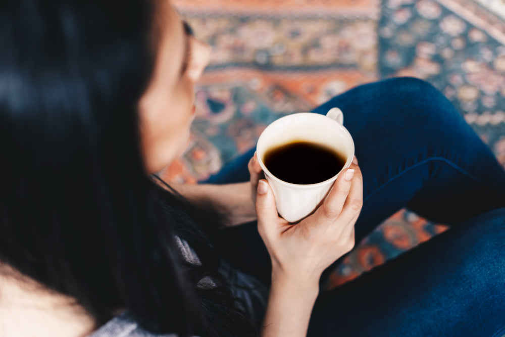 woman enjoying a cup of black coffee