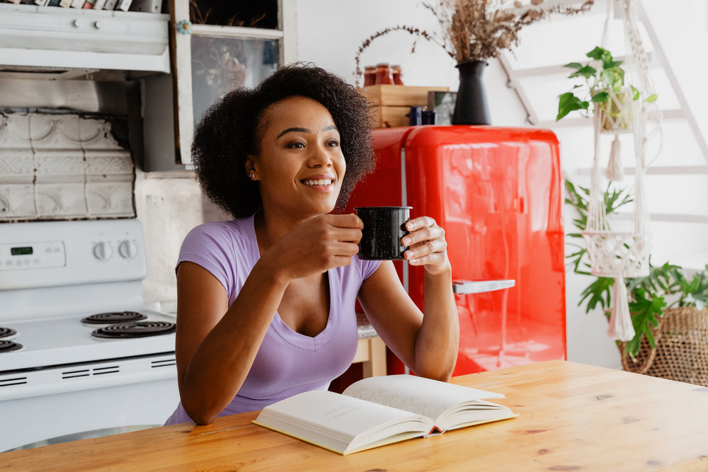 woman enjoying coffee and book in the kitchen