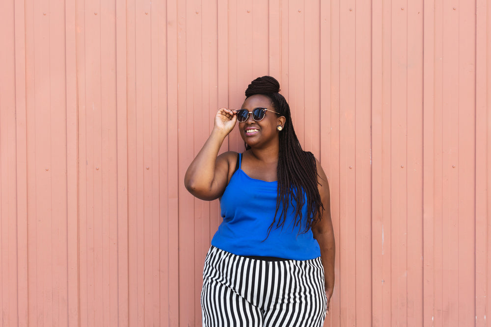 woman fashion model poses by pink wall