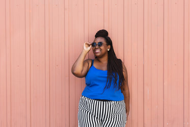 woman fashion model poses by pink wall