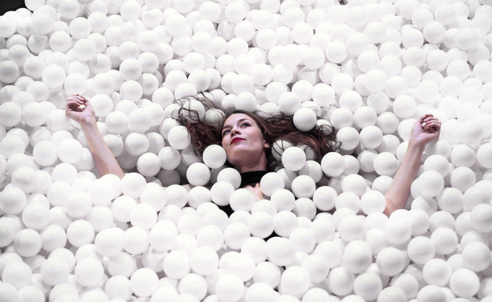 woman floating in a sea of styrofoam balls