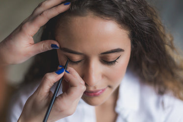 woman gets eyeliner applied