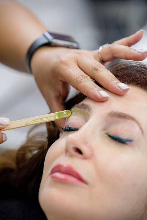 woman getting wax on her eyebrows