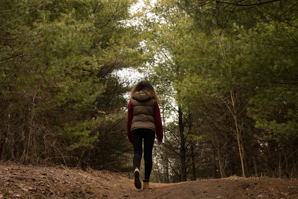 woman hikes through forest clearing