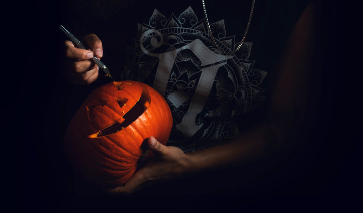woman-holding-a-scalpel-carves-a-pumpkin