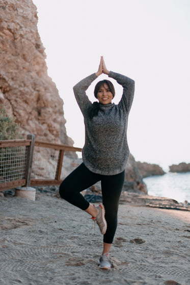 woman holding a yoga position on the beach