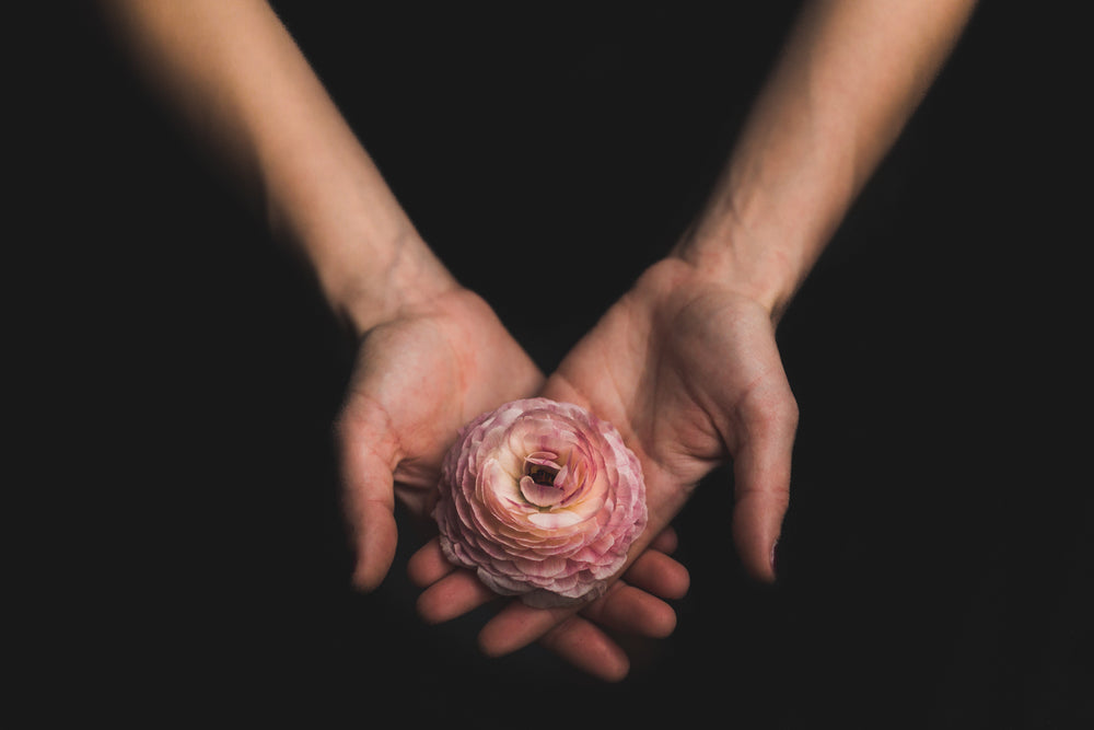 mulher com uma flor nas mãos