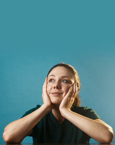 woman holding her face in both her hands