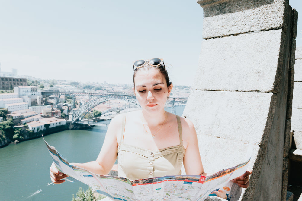 woman holds a city map open in both hands and looks at it