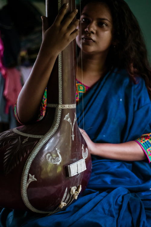 woman holds a large musical instrument
