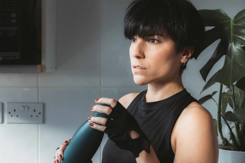 woman holds a water bottle and looks to the left