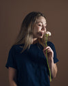 woman holds and smells a single ranunculus flower